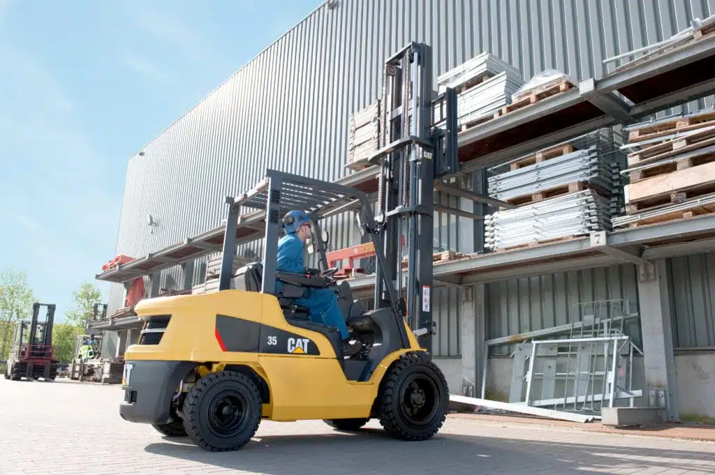 Worker operating forklift at industrial site